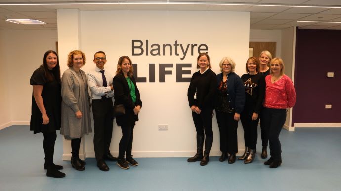 gruppebilde foran vegg der det står Blantyre Life, 9 personer