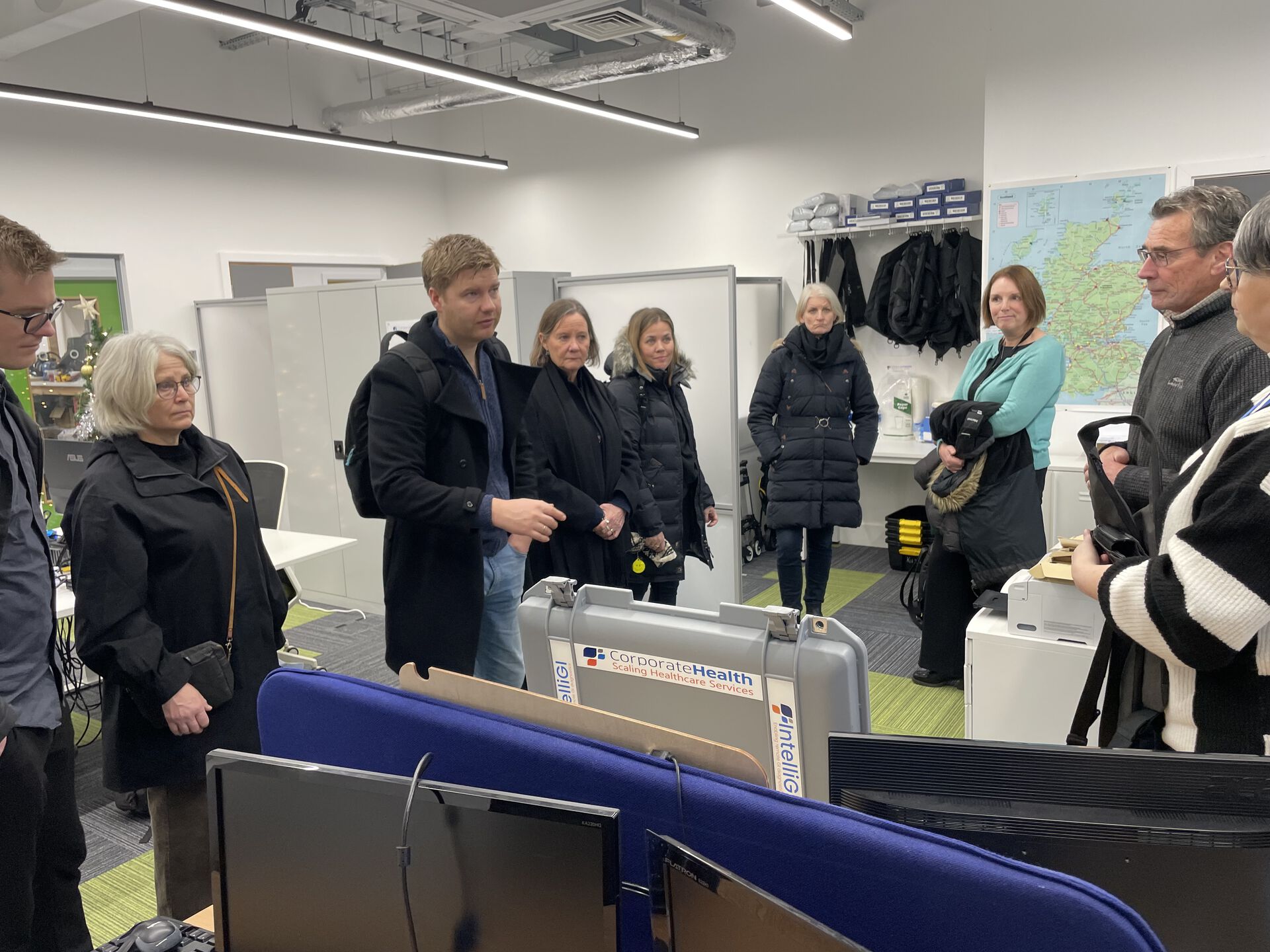 gruppe mennesker som står inne på et kontorområde