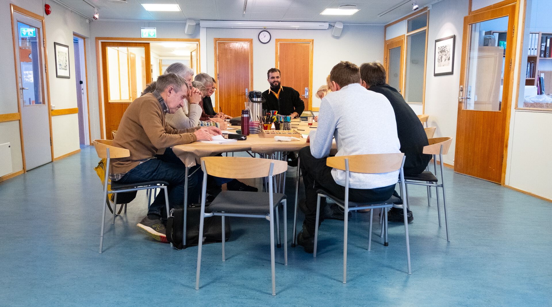 A group of people gathered around a table, drawing