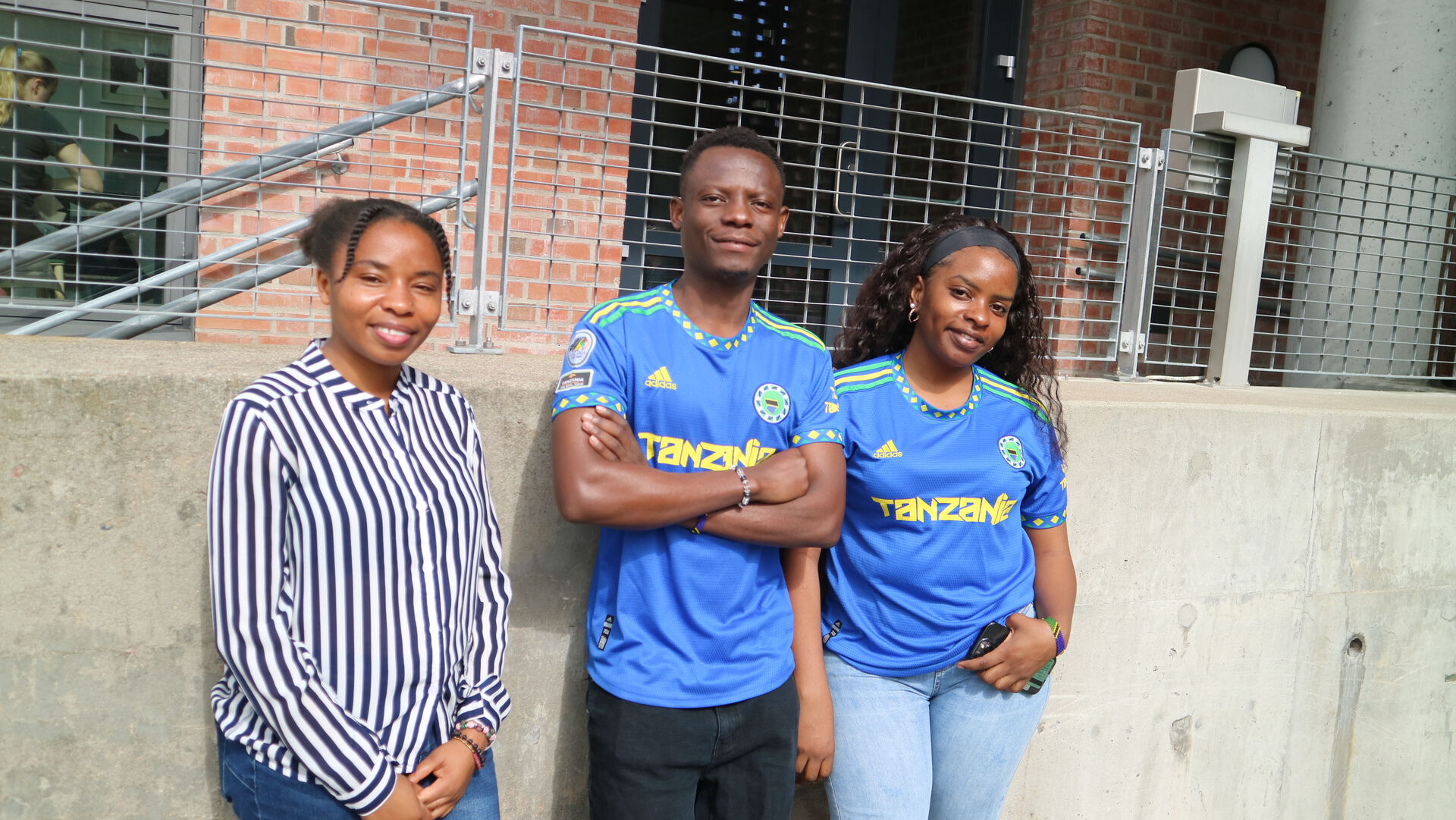 The three students outside the university building