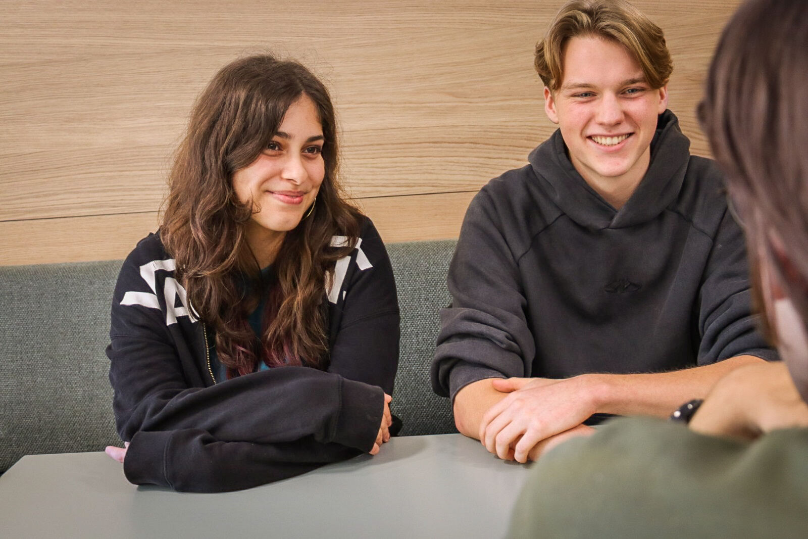 Two students talking to a third student
