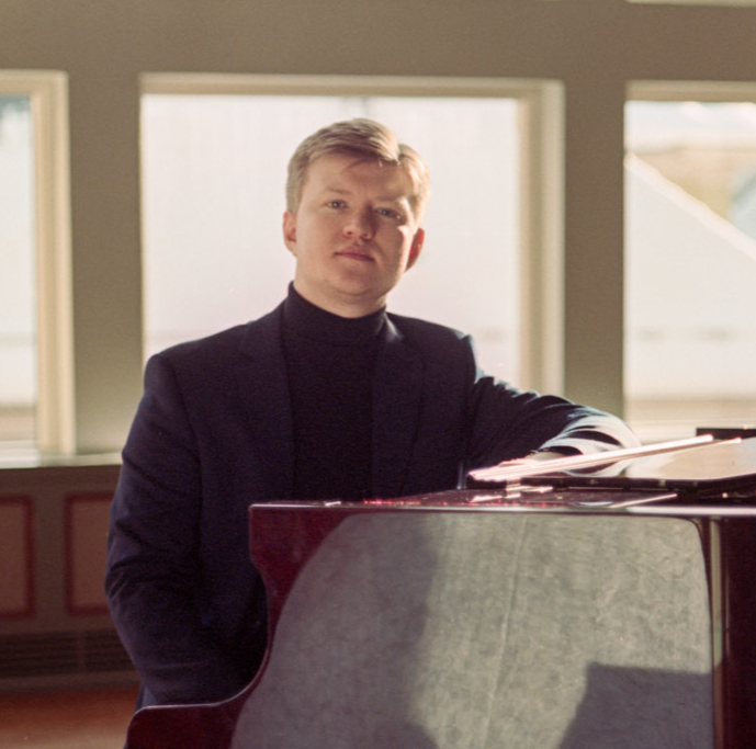 Sivert is sitting by a grand piano and looking into the camera