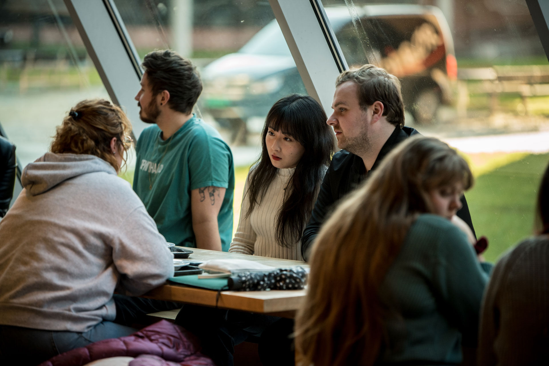 Photo of a group of students sitting around a table talking to each other