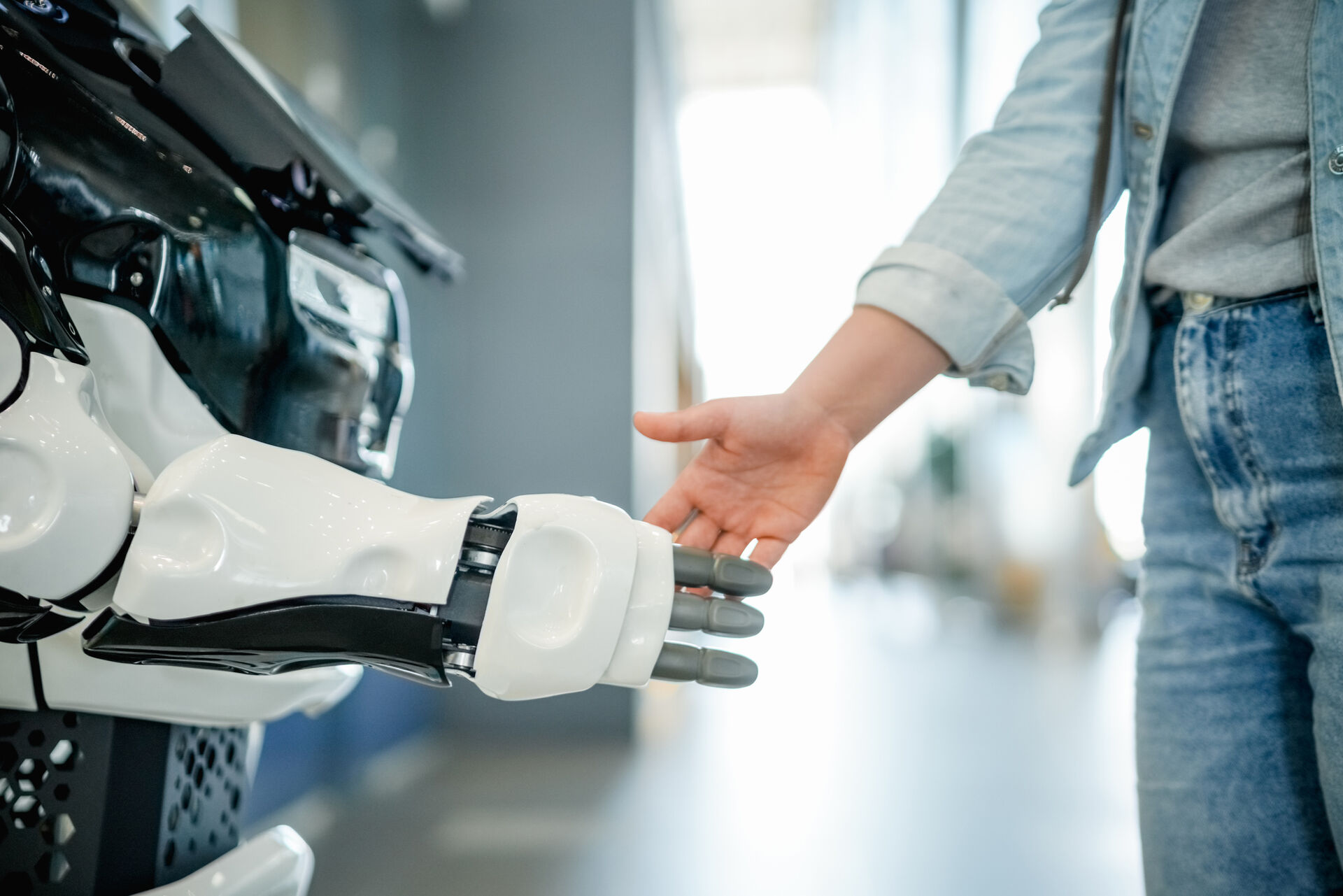 Illustrasjonsfoto av en robot og et menneske som interagerer.