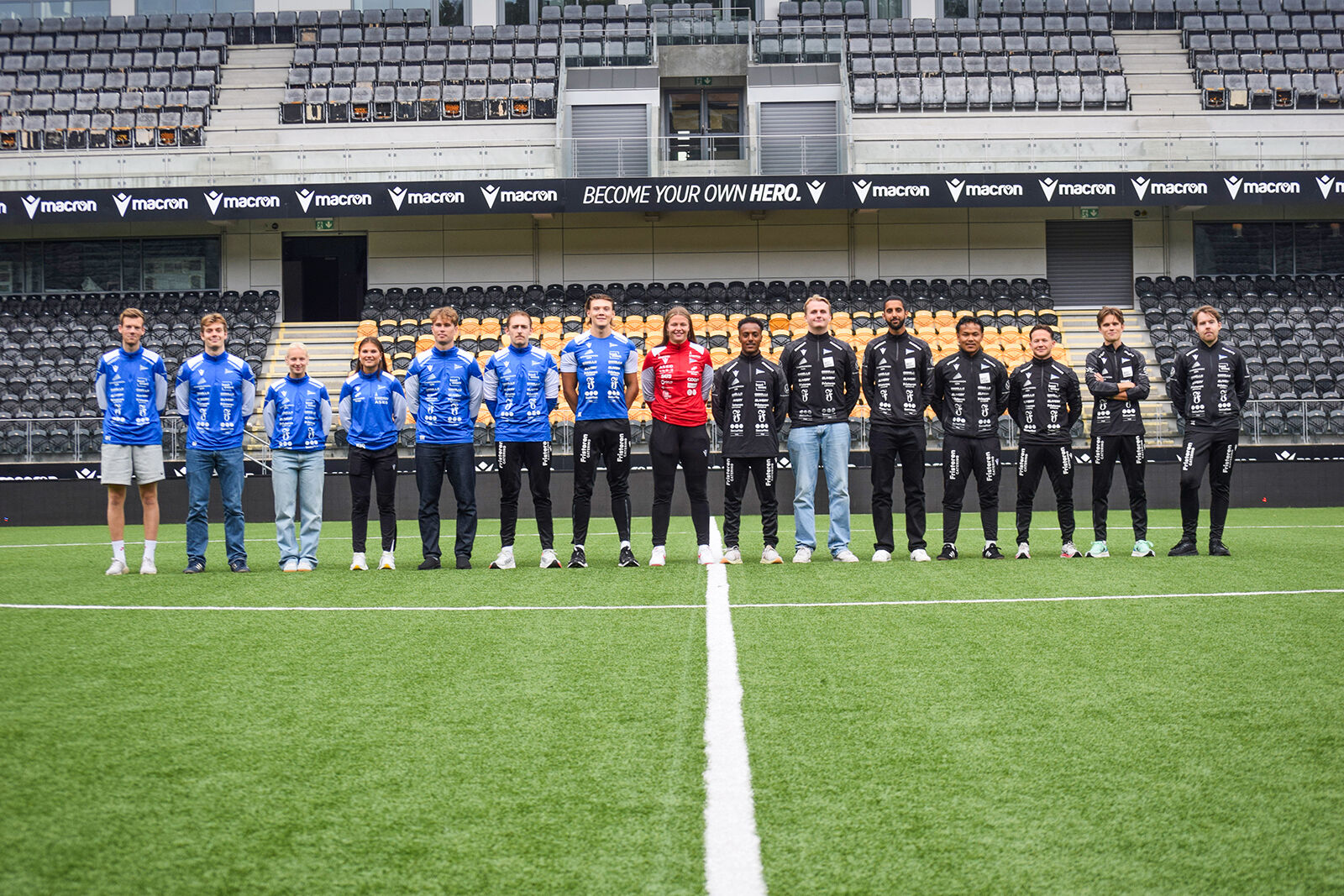 Bildet viser studenter i idrettsklær som står på en fotballbane.