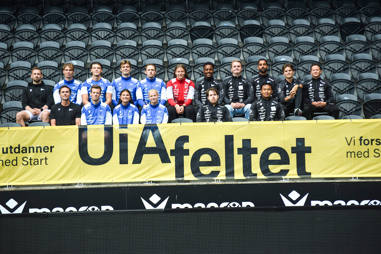 Bildet viser studenter som sitter samlet på en fotballtribune.