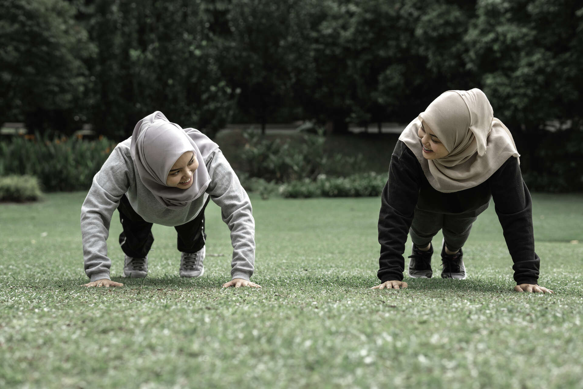 To jenter med skaut gjør push-ups i en park