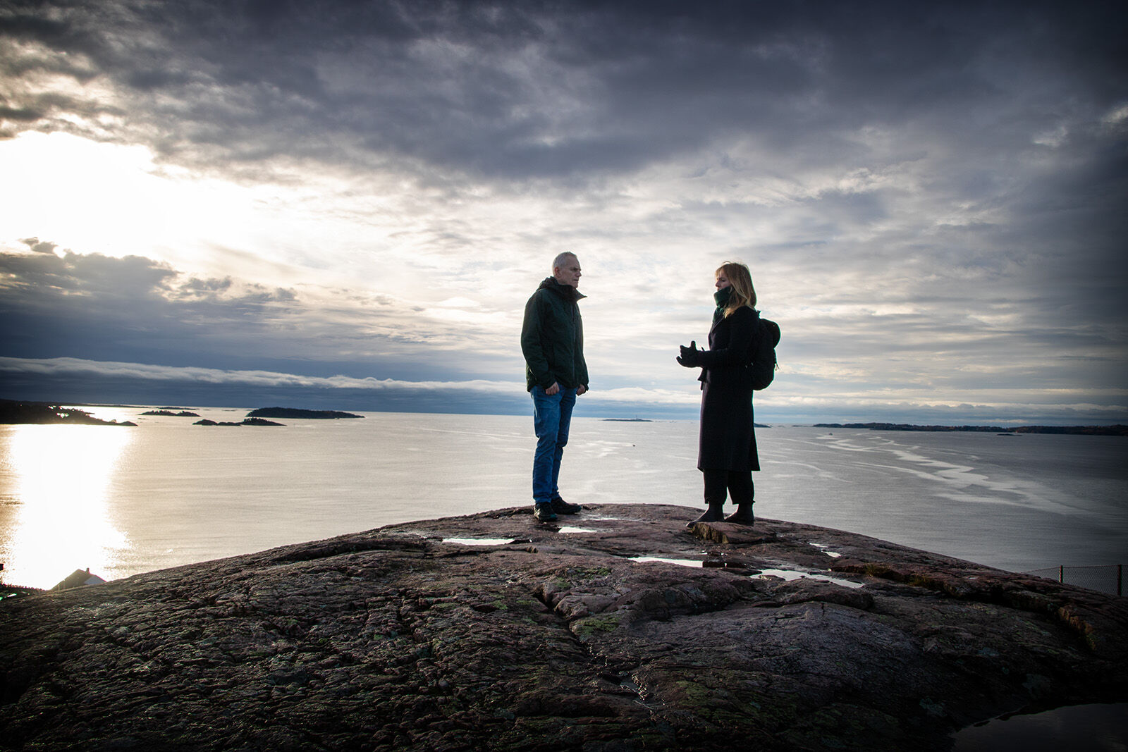 Bildet viser forskerne som står oppe på Trollkjerringheia. Det er utsikt over havet fra toppen.