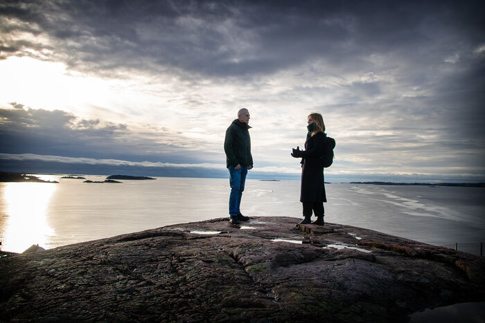 Bildet viser forskerne som står oppe på Trollkjerringheia. Det er utsikt over havet fra toppen.