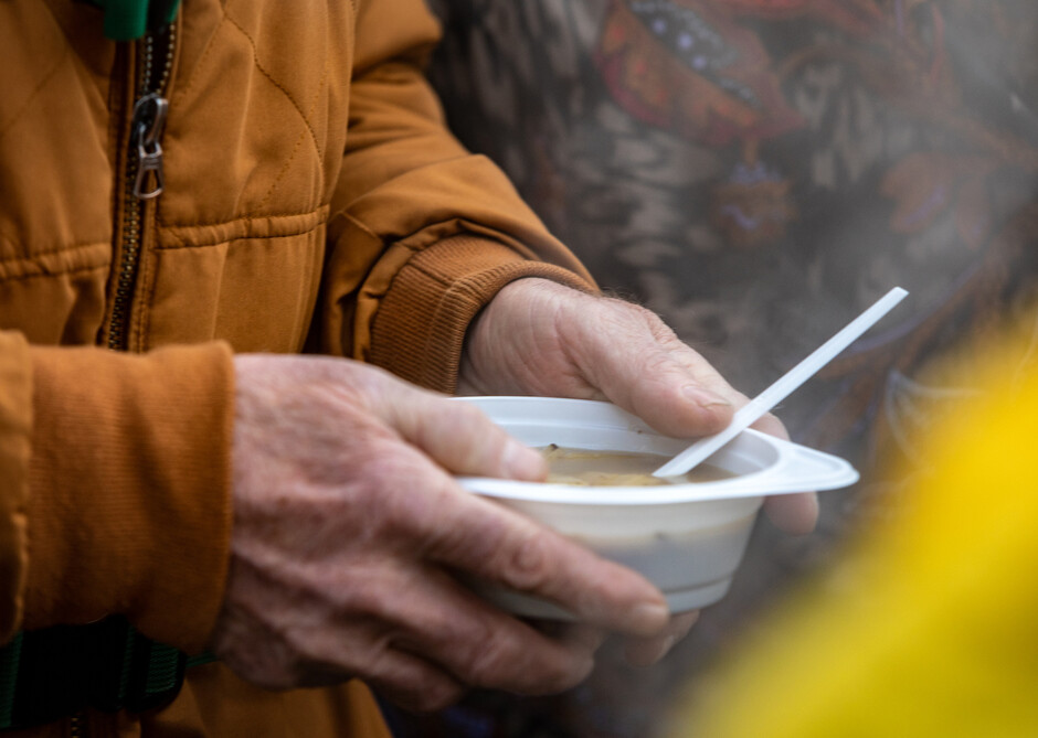 Bildet viser en mann som holder en skål med suppe.