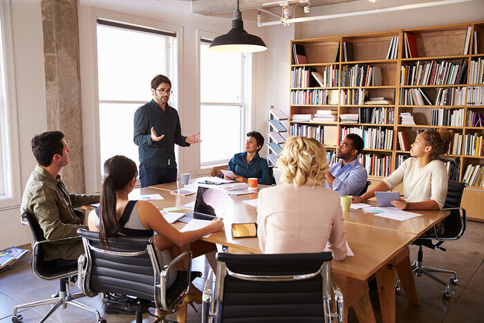 Group sitting around a table listening to a presenter