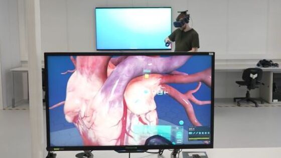 person med vr-briller på, skjerm som viser bilde av et hjerte