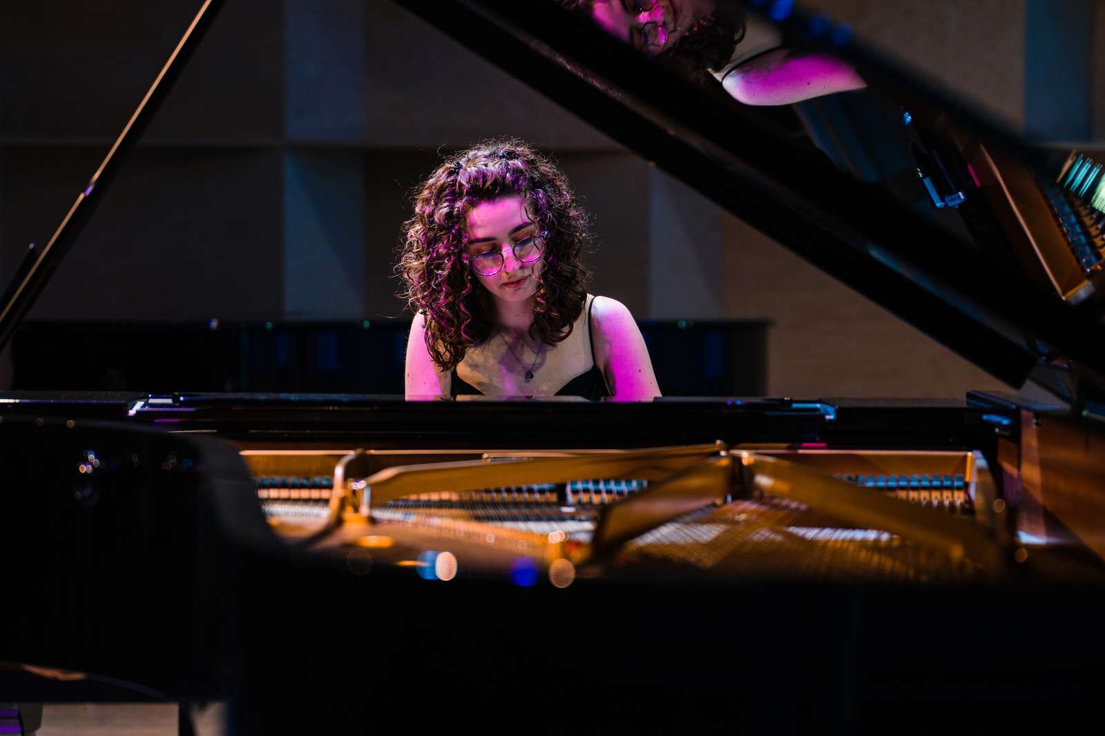 a photo showing a woman playing a grand piano