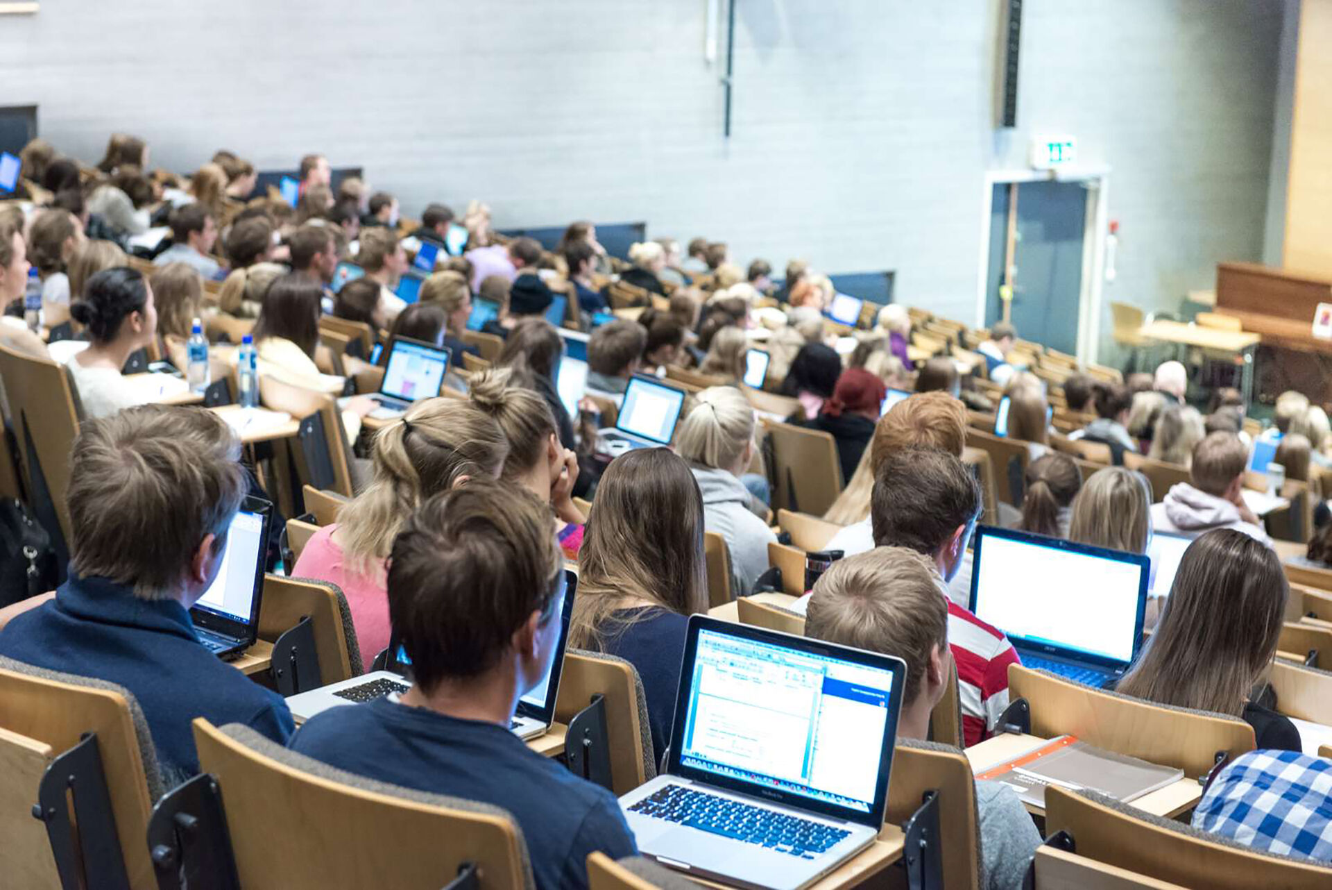 Bildet inneholder mange studenter i et auditorie