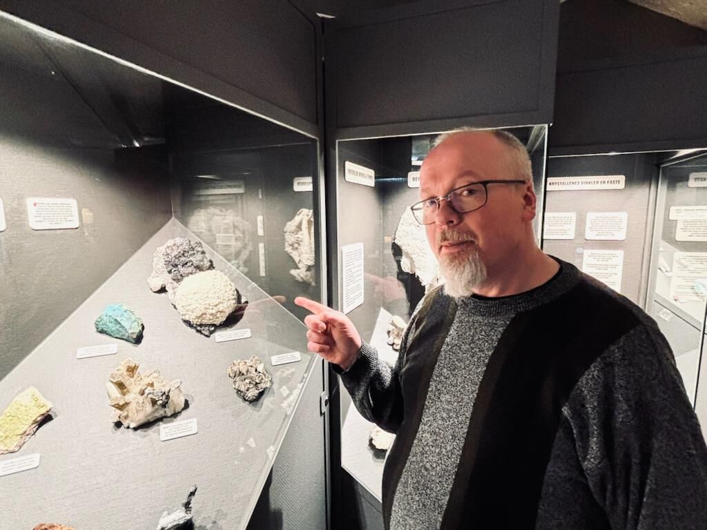 Geolog viser mineraler i et monter