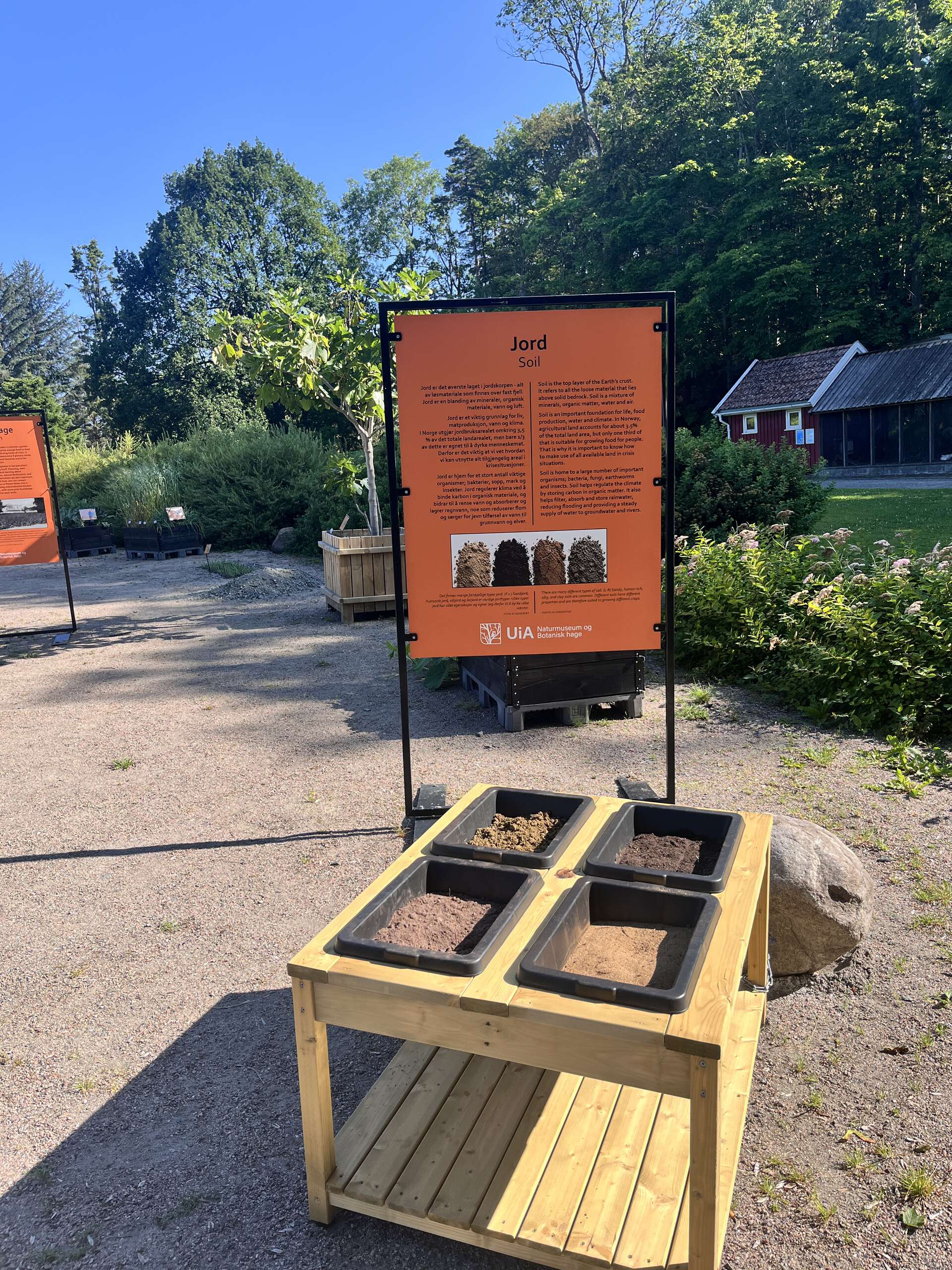 Wooden table with four boxes of soil. Orange sign