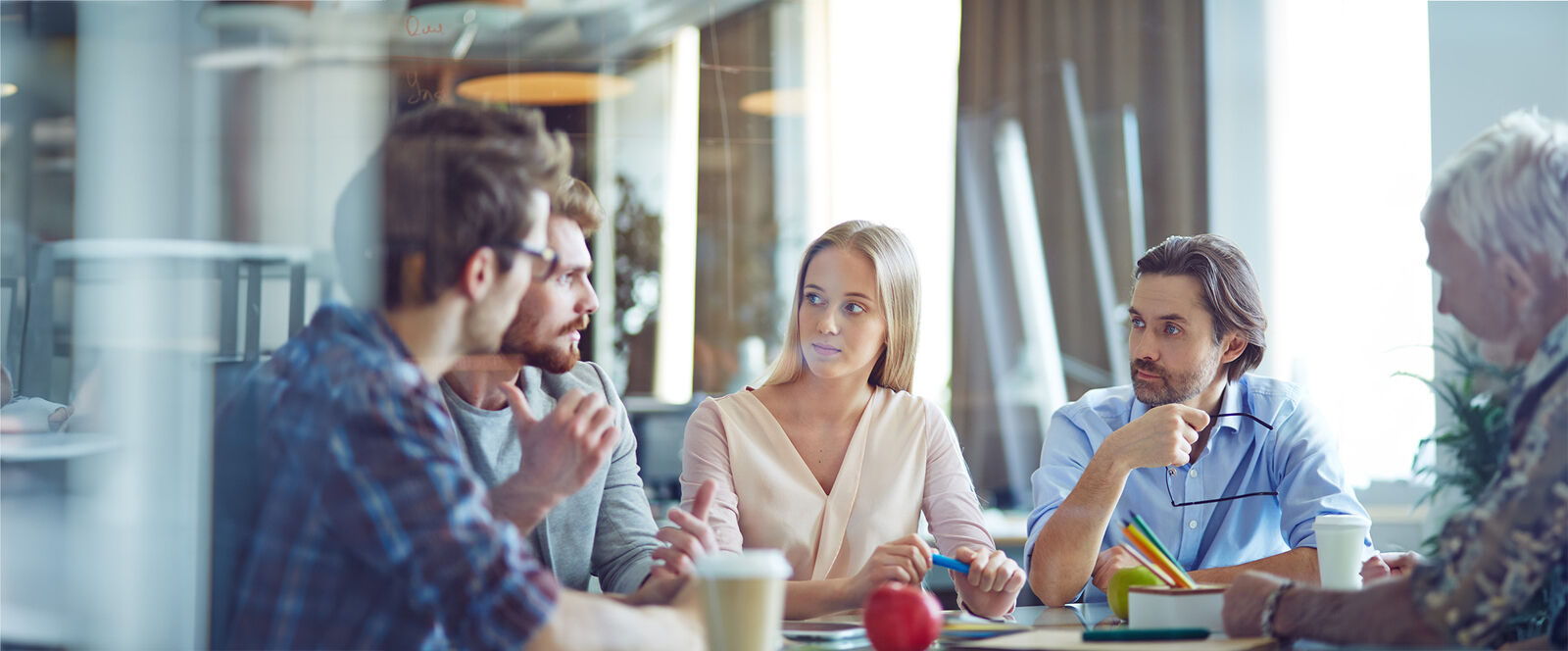 5 people sitting and discussing around a table