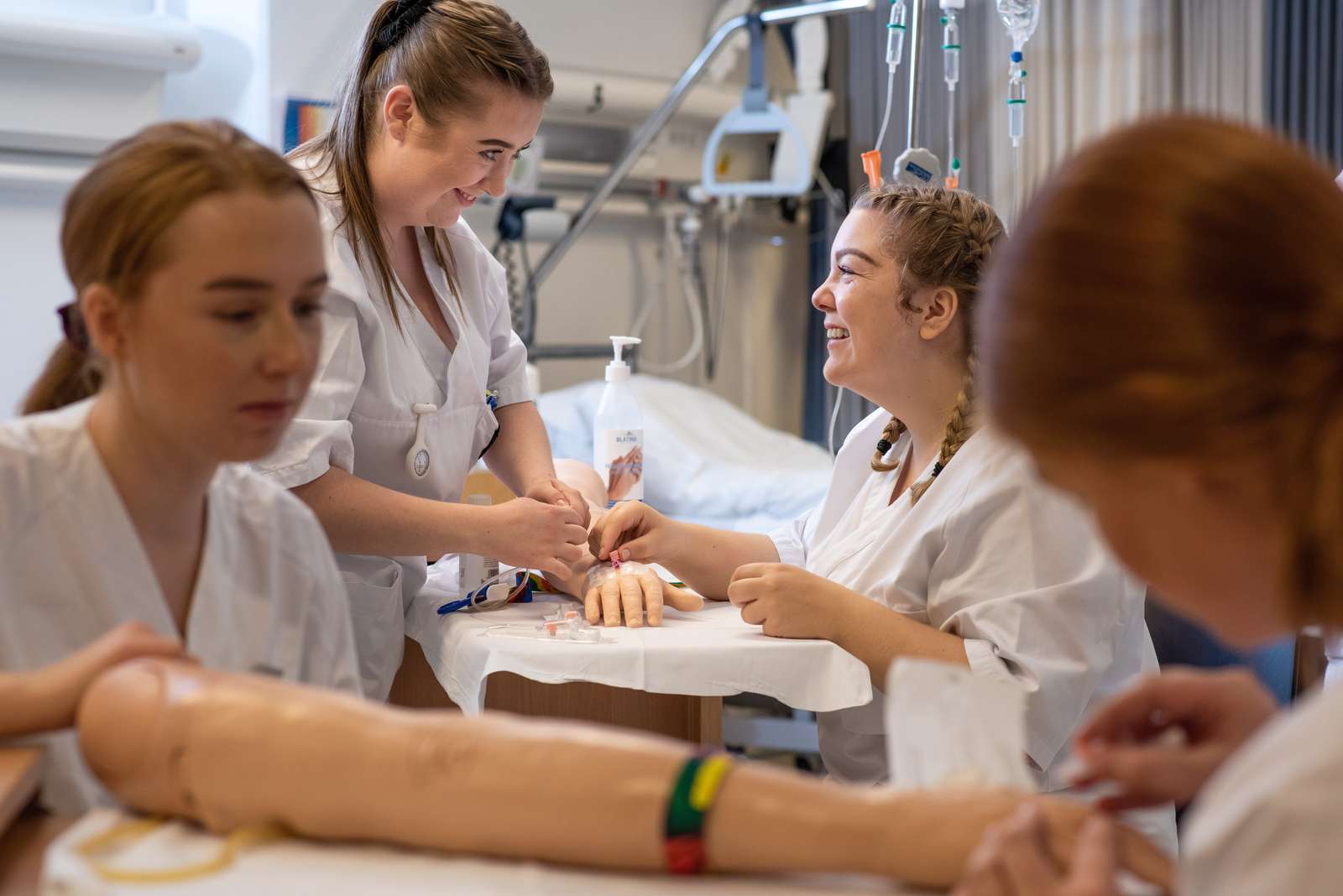 Illustrasjonsbilde av fornøyde sykepleierstudenter som øver seg