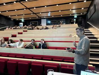 Bildet kan inneholde: møbler, publikum, stol, auditorium, konferansesal.
