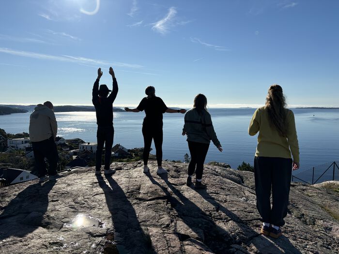 Bilde av masterstudenter som jobber med et kunstprosjekt ute