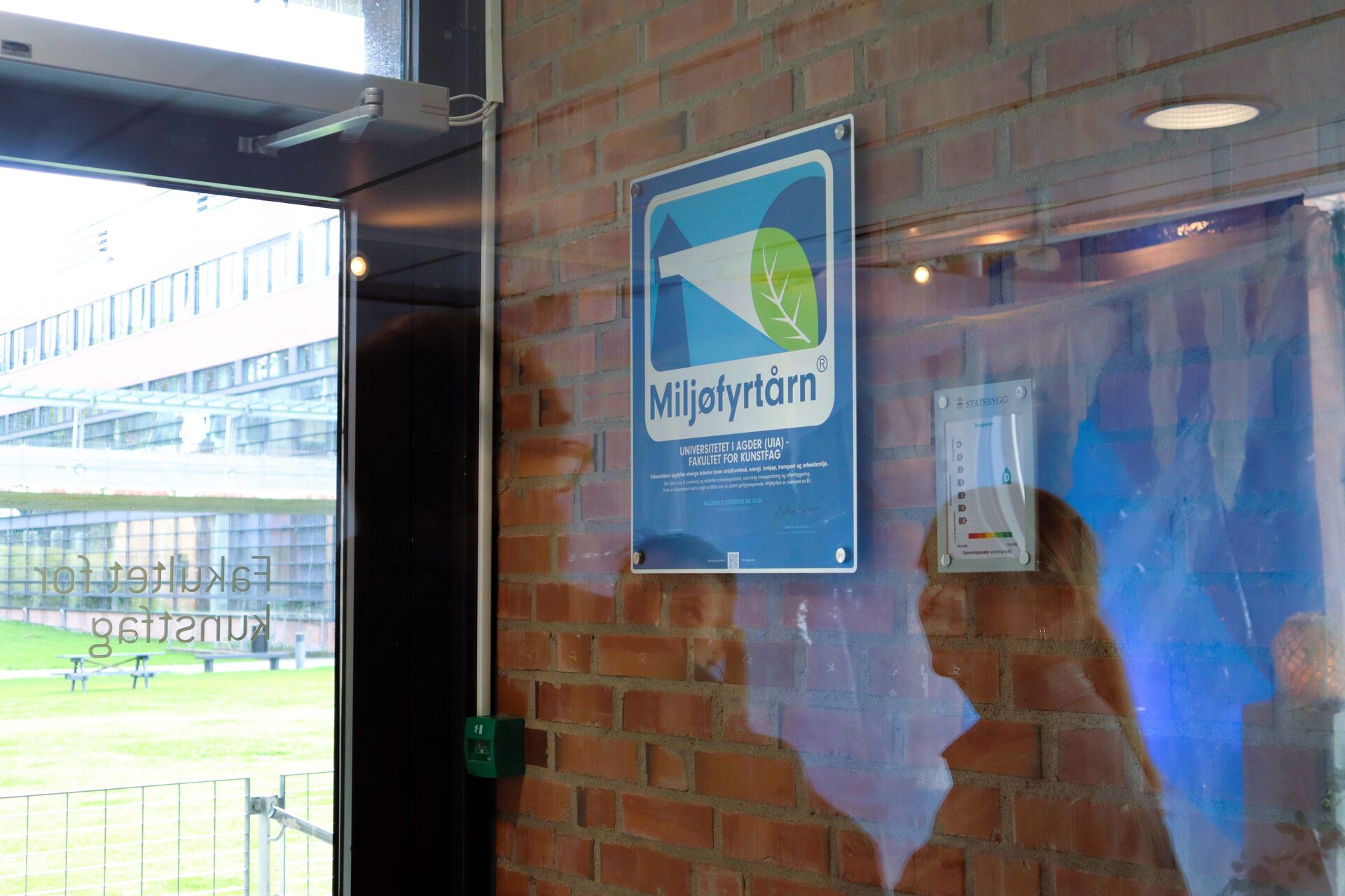 Bilde av Miljøfyrtårn-plakett på veggen på UiA 