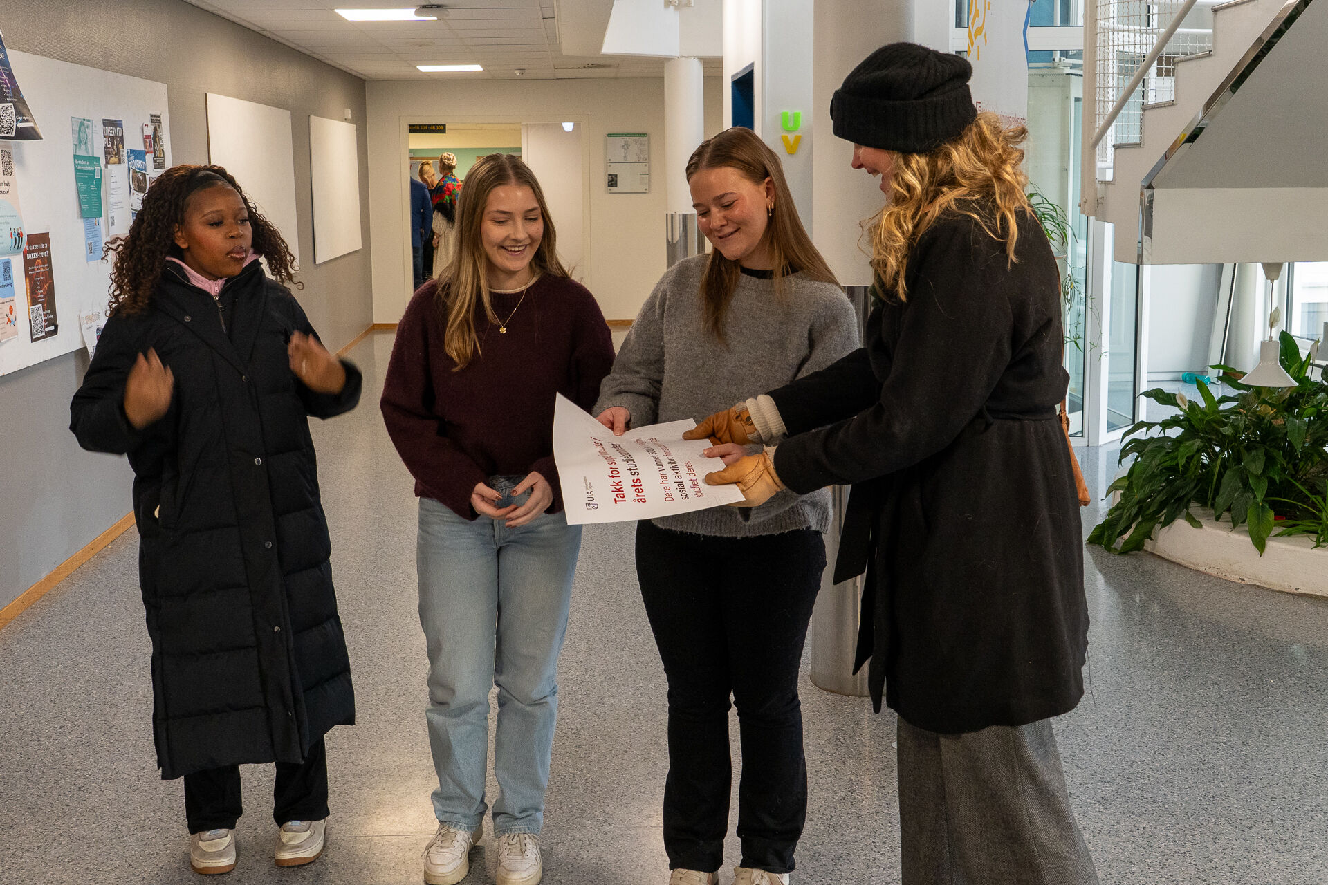 Bildet viser tre studentar som tek imot gåvebevis frå ei dame
