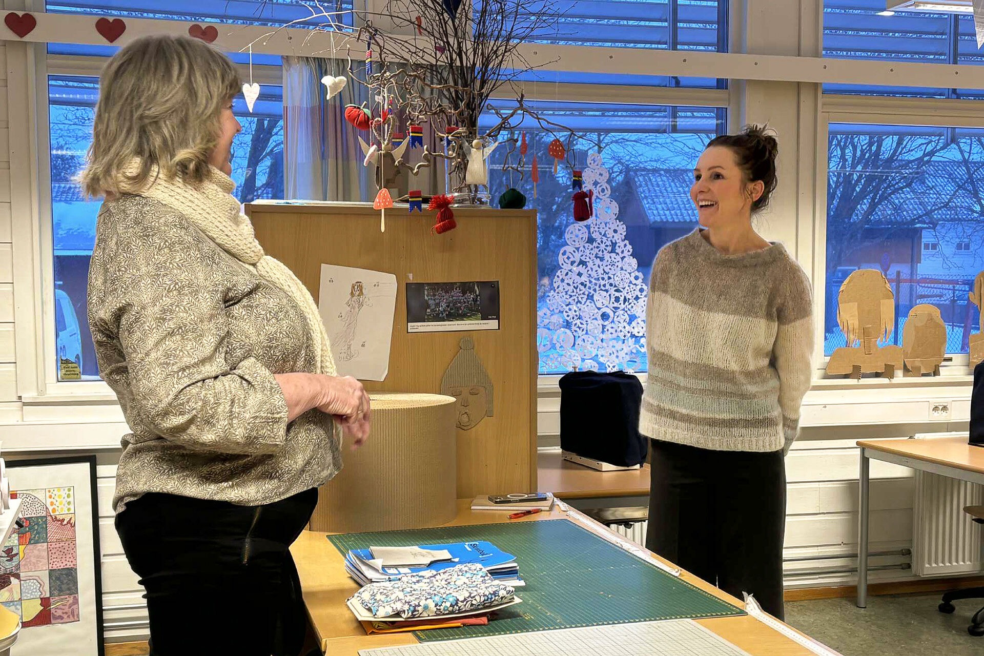 Camilla og Anne Kristin i samtale, bord, kunst, klasserom