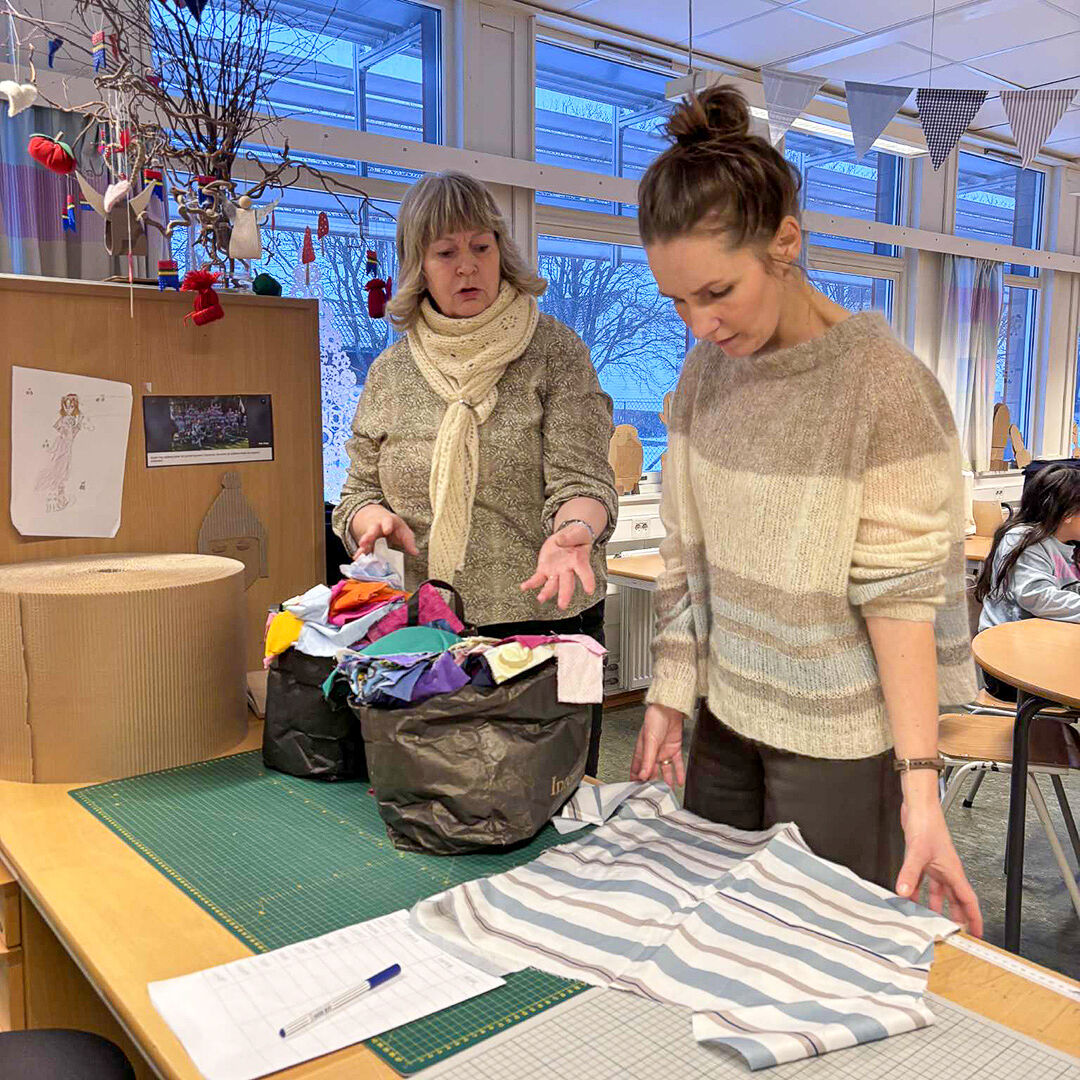 Camilla og Anne Kristin samtaler mens de lager til et forkle