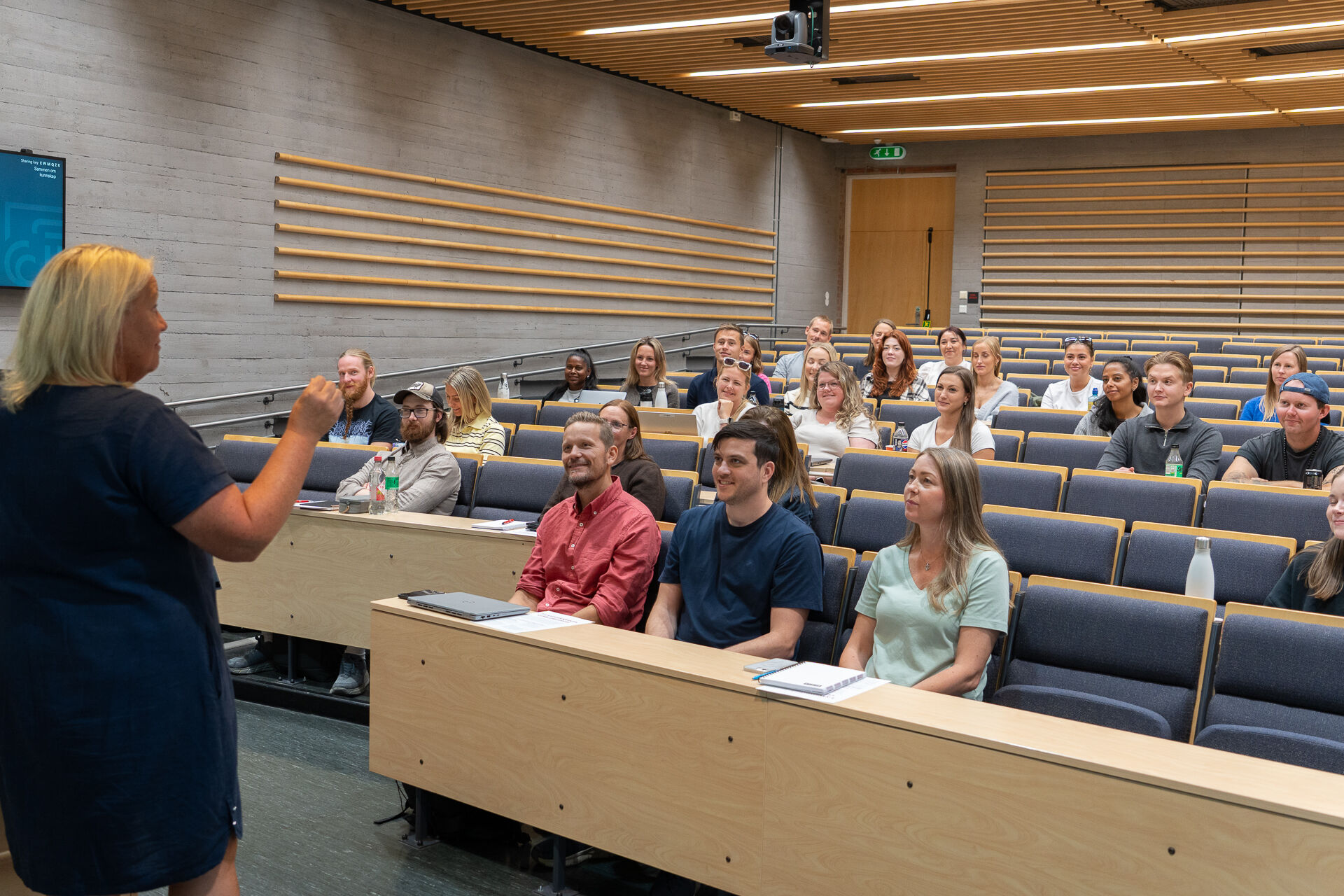 Bildet viser studentar i auditorium som høyrer på studieleiar