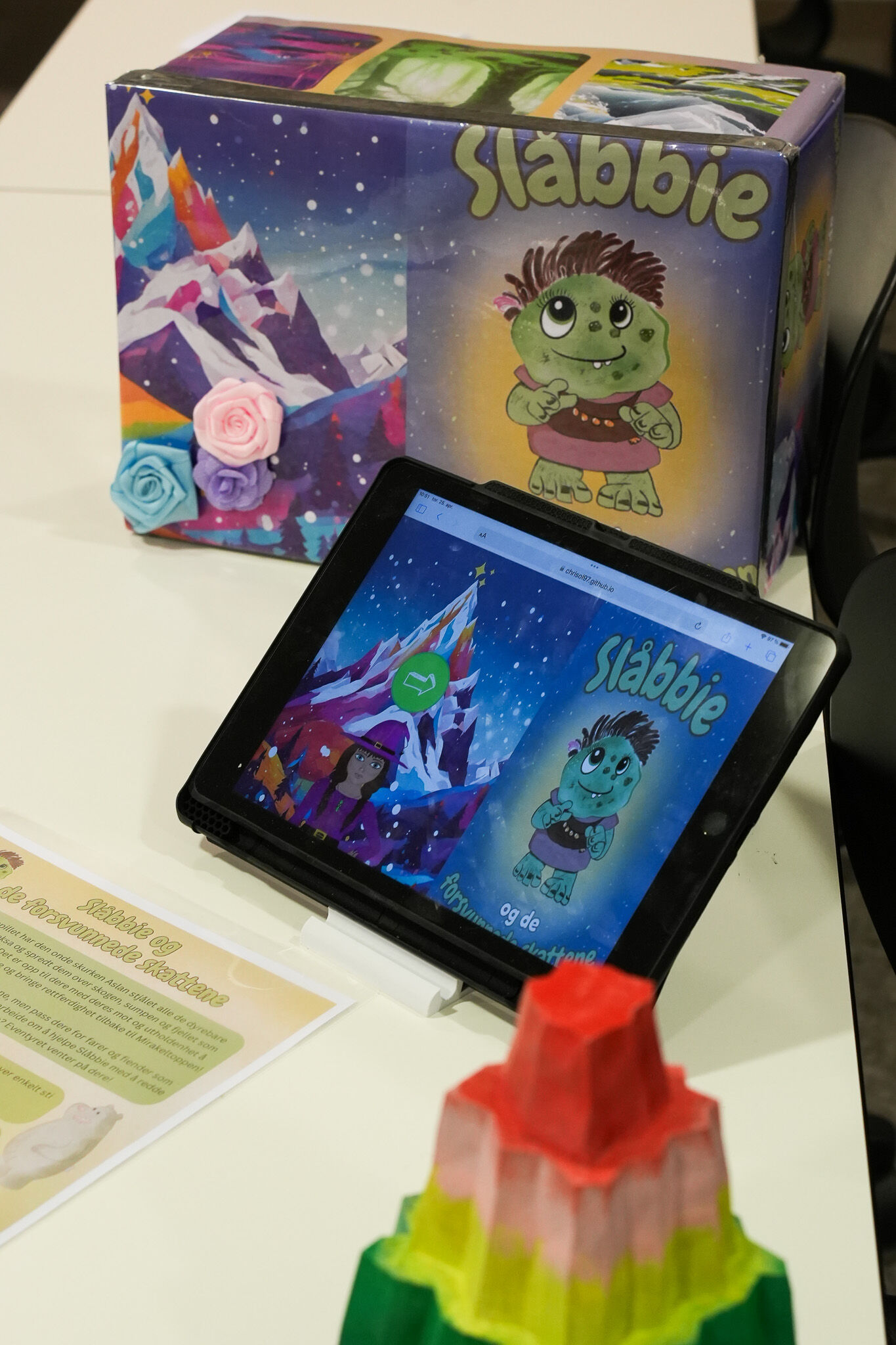 iPad med programvaren til spillet Slåbbie åpent, spillboks til spillet