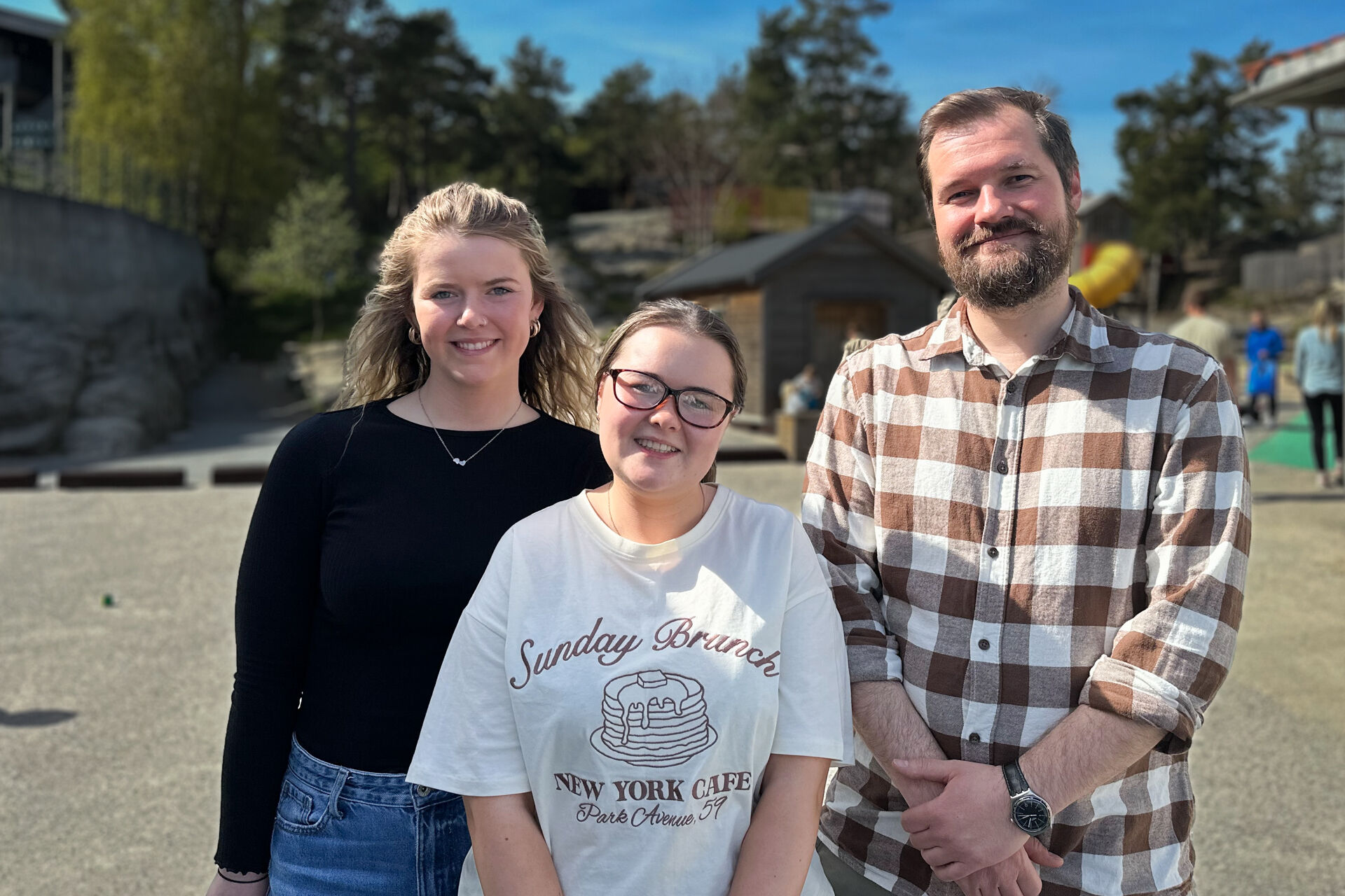 Gruppefoto av studentene Sarah og Louise sammen med praksislærer Kai Arne. Står i uteområdet til Hokus Pokus.