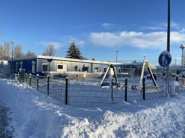 Bygning med huskestativ foran og snø