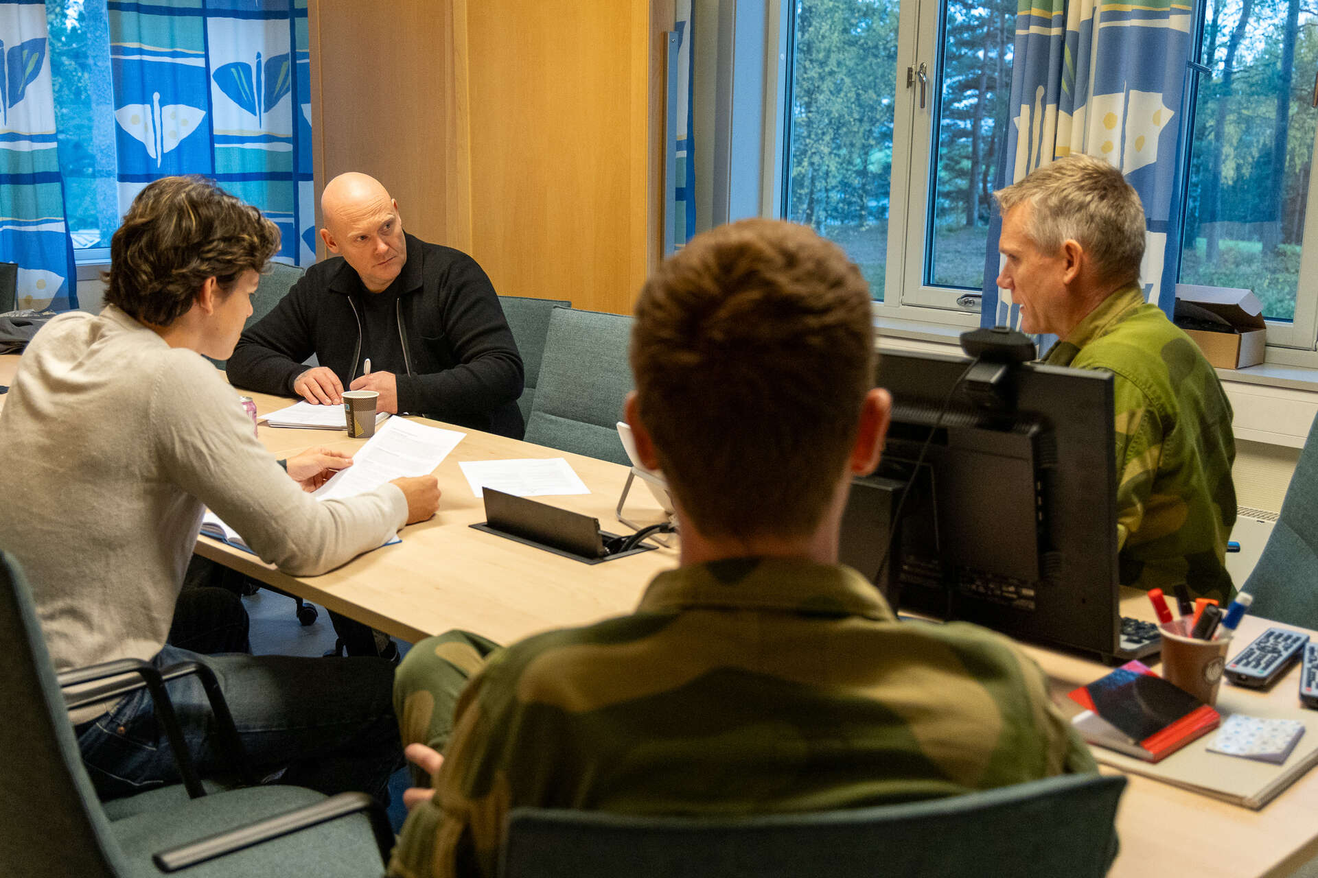 Kay Arne og studenter sitter rundt møtebordet sammen med uniformerte representanter fra HV-07.
