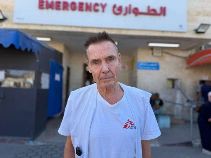 Morten Rostrup i hvit vest med Leger Uten Grensers logo foran inngangen til et akuttmottak.