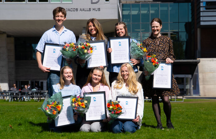 Deltakerne foran UiA med diplom og blomster.