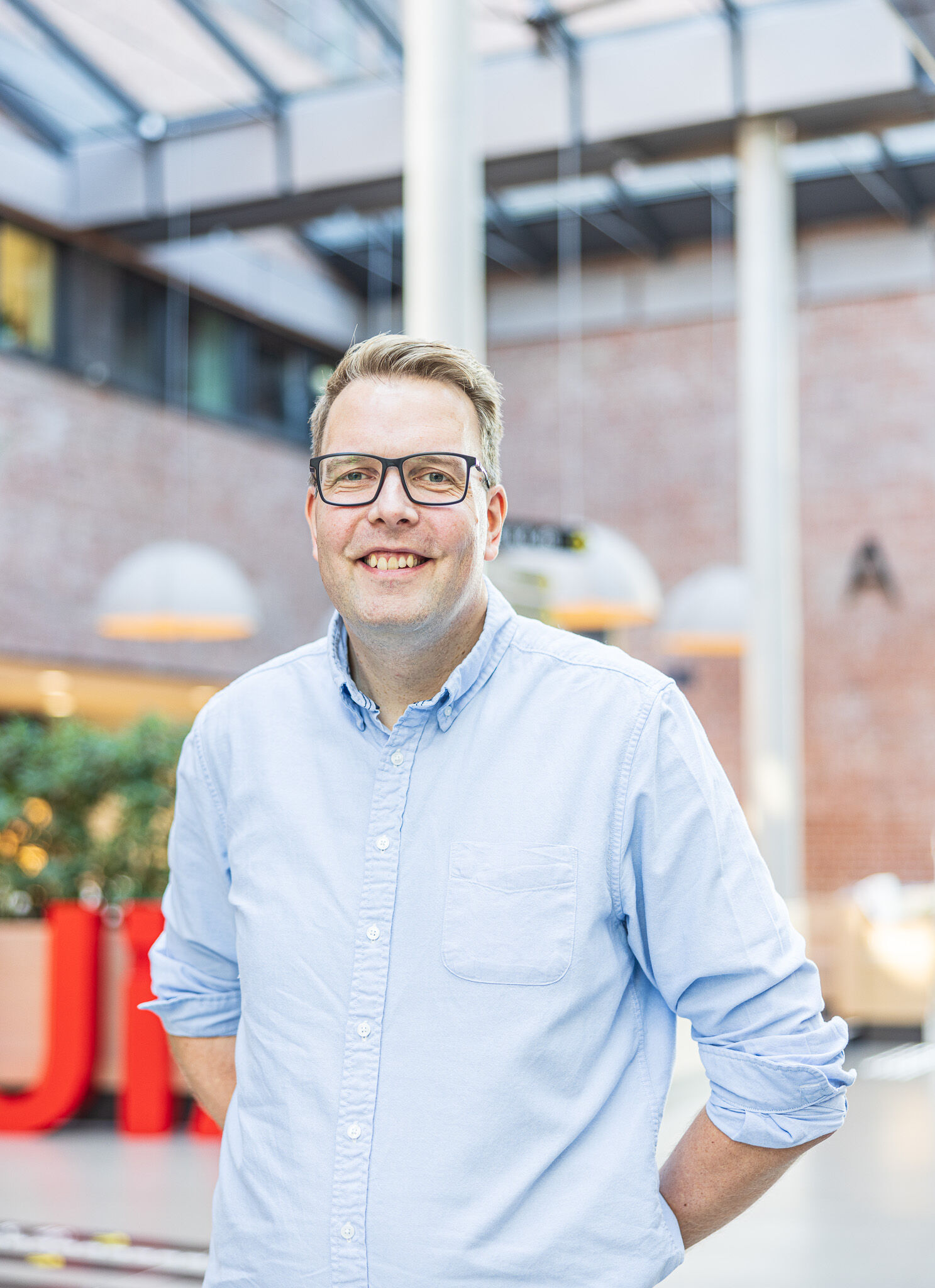 Bildet kan inneholde: briller, smil, skulder, synsomsorg, kjole skjorte.