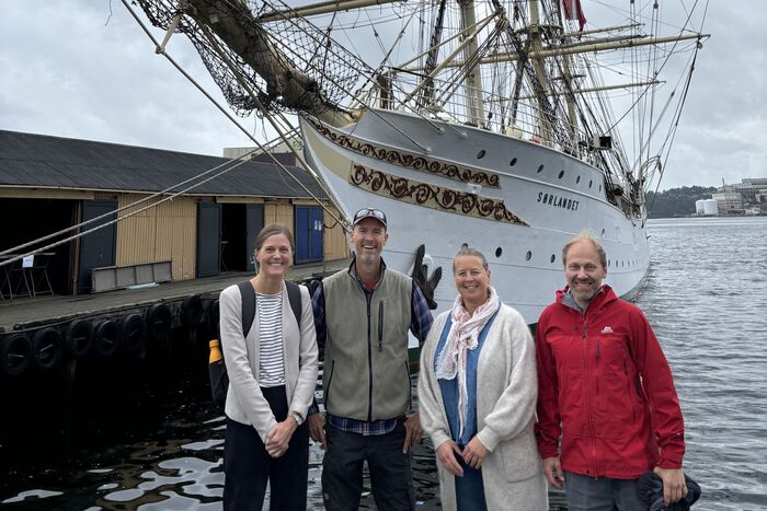 Photo of researchers in front of tall ship
