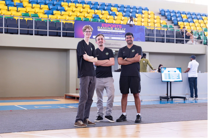 Bilde av tre studenter i en gymsal