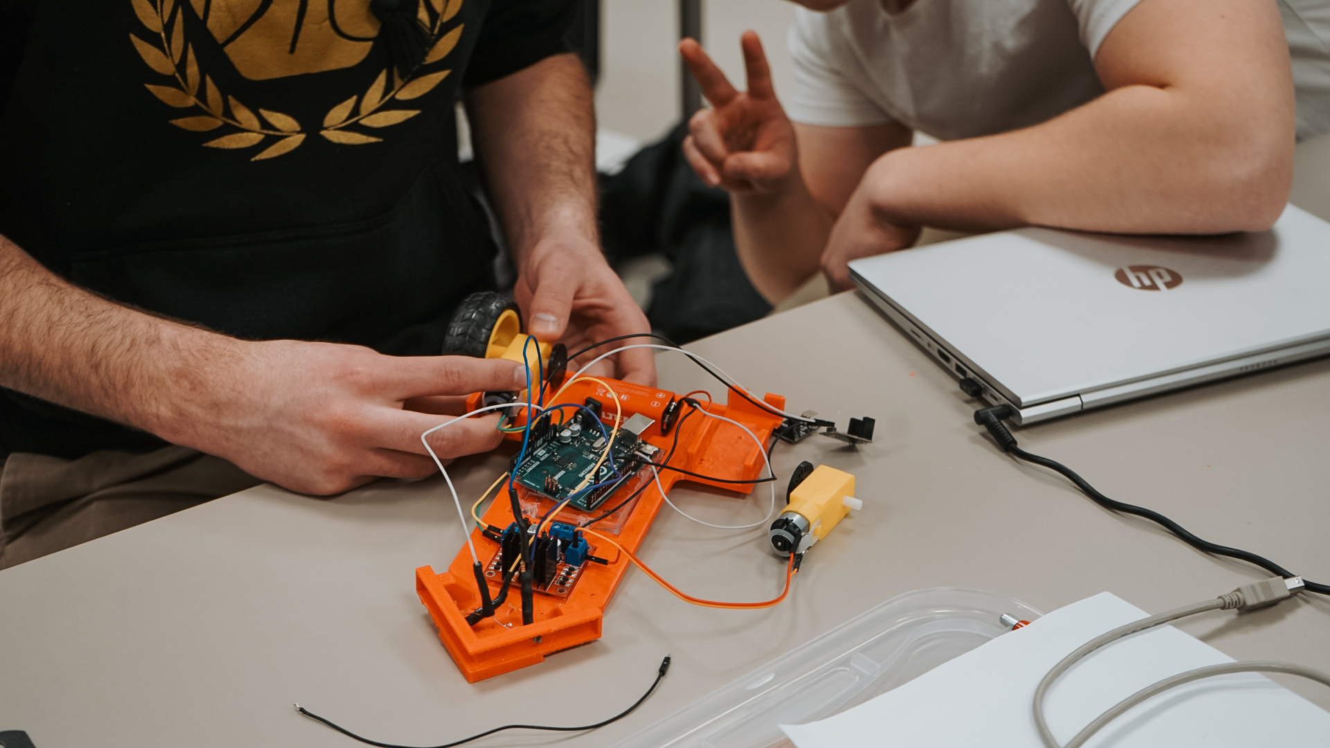 Bildet kan inneholde: hånd, bildesign, engineering, t skjorte, elektronikkteknikk.