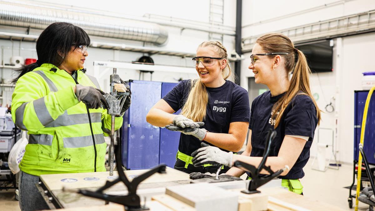 Three people wearing safety glasses interacting in a laboraty setting