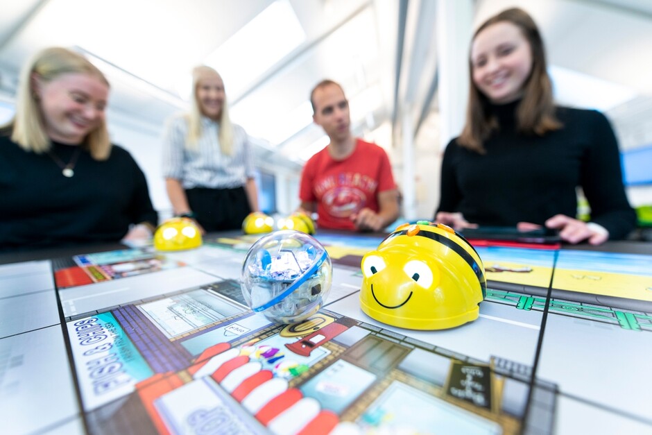  Fire glade studenter er samlet rundt et spill