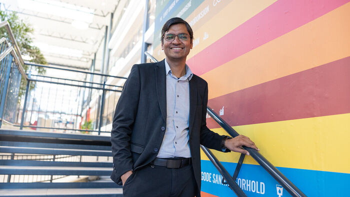 Dekan Vikas Thakur avbildet i en trapp, med en hånd på gelenderet. Ikledd dress.