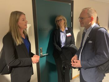 Bildet kan inneholde: ledd, frakk, stående, gest, slips.