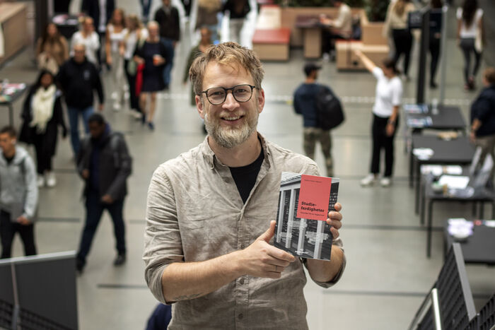 Bildet viser Stefan Fisher-Høyrem som holder opp sin nye bok.
