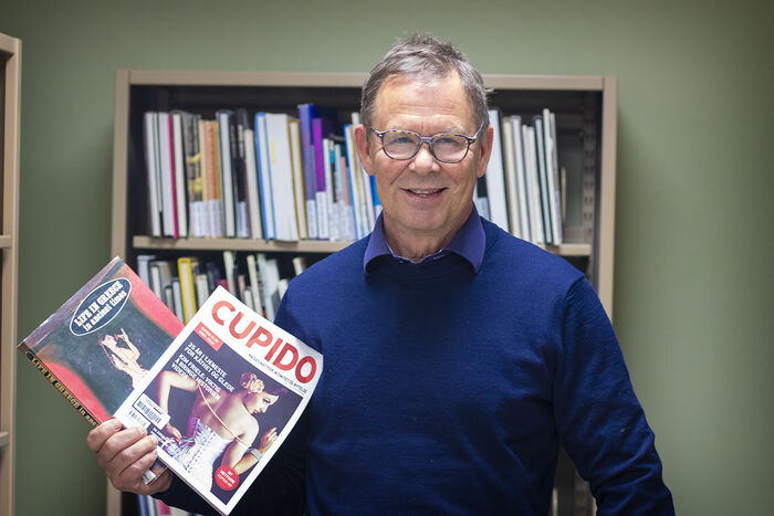 The picture shows Professor Tor-Ivar Karlsen holding up two magazines from the collection.