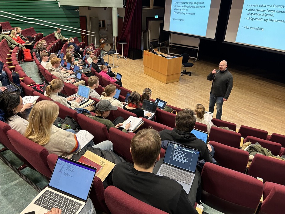 Professor Knut Dørum underviser i en lesesal fylt med studenter.