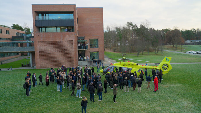 Bildet viser et helikopter med studenter rundt.