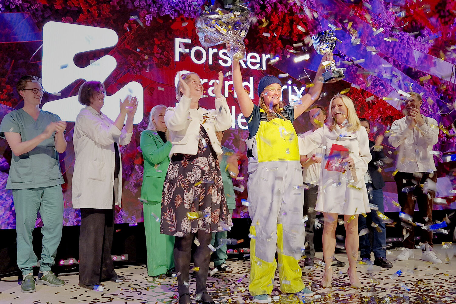 Doktorgradsstipendiat Johanna Bjånes Marcussen ved UiA og Havforskningsinstituttet gikk torsdag kveld til topps i årets Forsker Grand Prix-finale i Oslo. Her sammen med fagdommer og adm. dir. Mari Sundli Tveit i Norges forskningsråd (t.h.) og kveldens konferansier Solveig Kloppen. (Fotograf er Stine Østby, Forskningsdagene.)