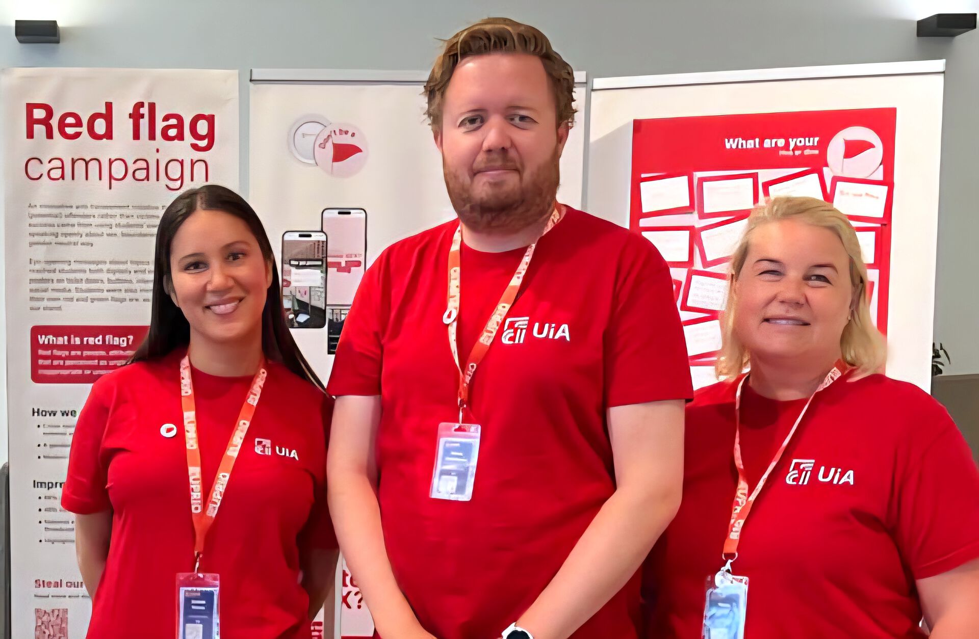 Tre UiA-ansatte foran Red flag-standen.