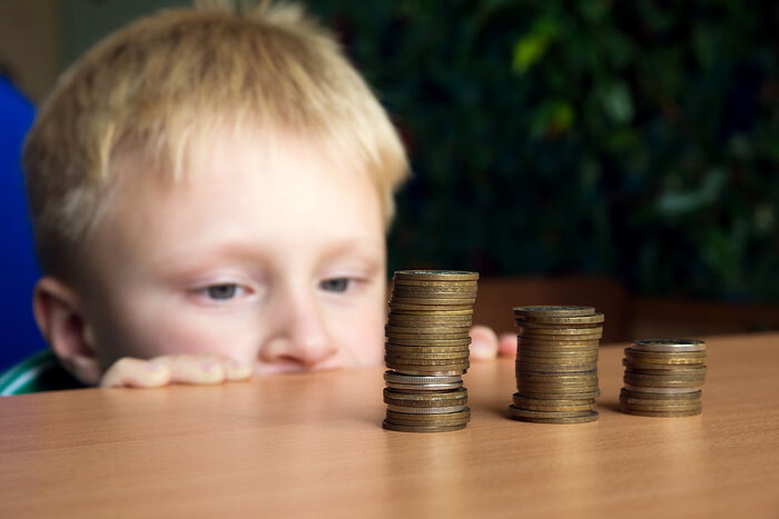 Picture of a young boy looking at stacks of coins